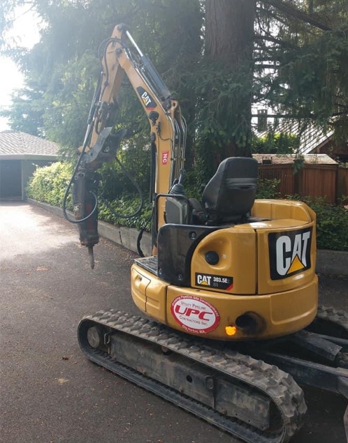 Mini excavator with hammer for breaking out of concrete pool